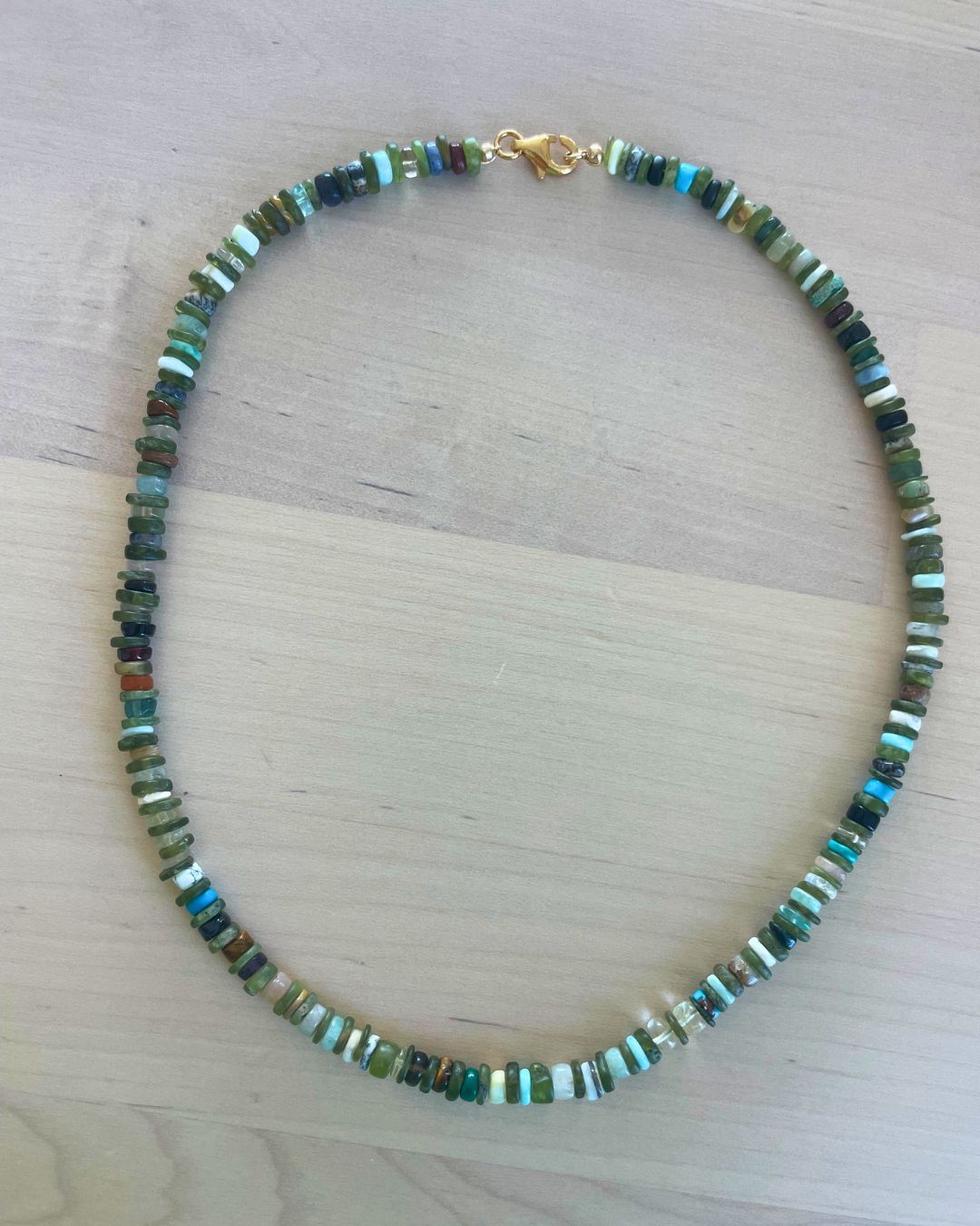 Necklace with multicolored beads on a light wooden surface