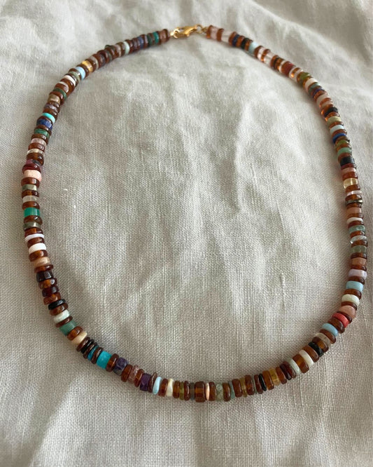 Multicolored beaded necklace on a light fabric background