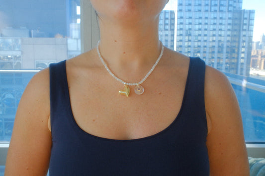 Person wearing a necklace with a blue background