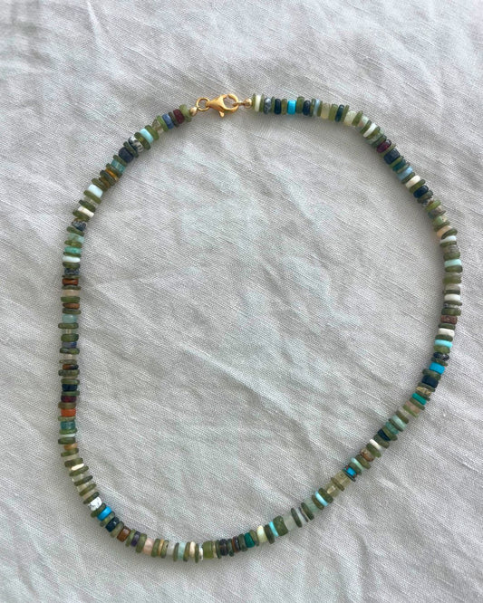 Necklace with multicolored beads on a light gray fabric background