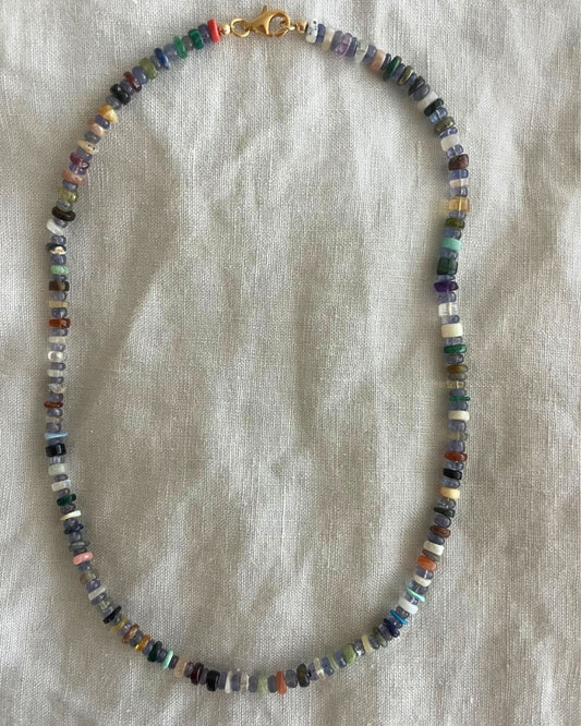 Multicolored beaded necklace on a light fabric background