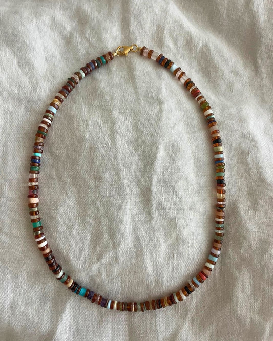 Multicolored beaded necklace on a light fabric background
