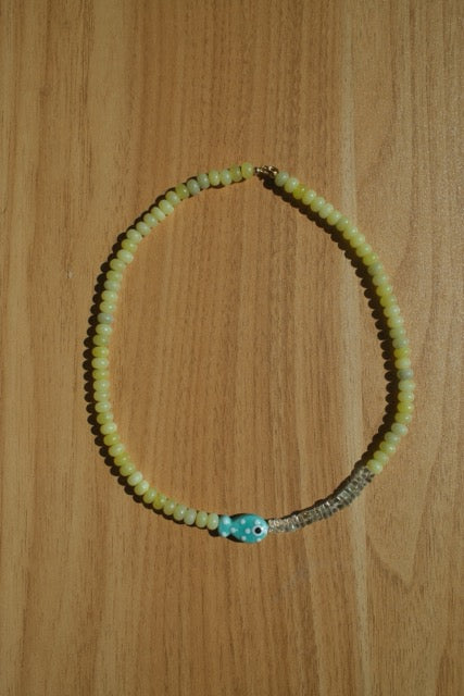 Necklace with green beads on a wooden surface