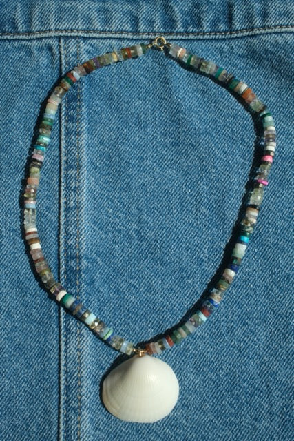 Necklace with a shell pendant on a blue denim background