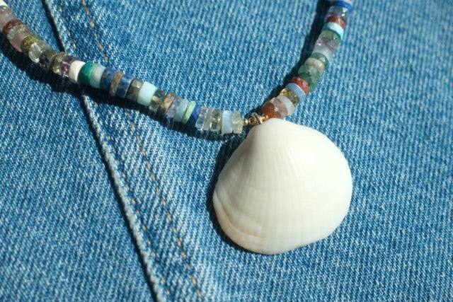 Necklace with beads and a shell on denim fabric