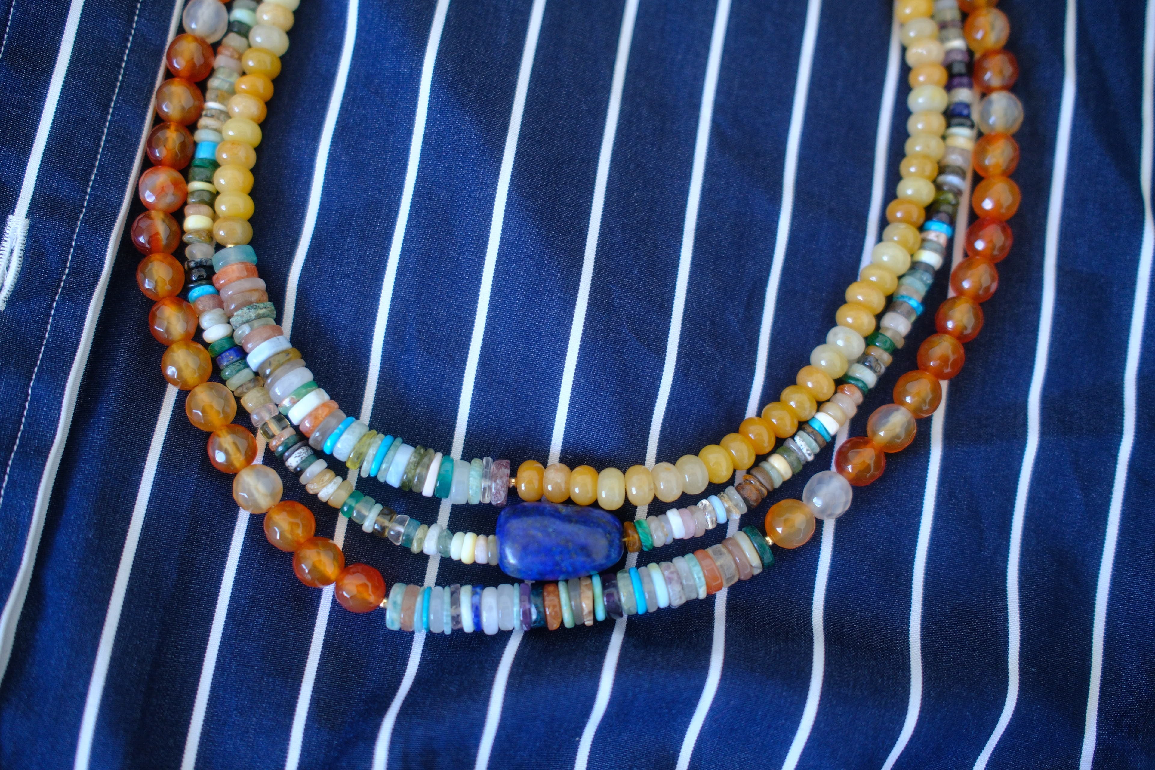 Beaded necklace on a blue and white striped fabric background
