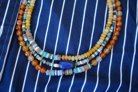Beaded necklace on a blue and white striped fabric background